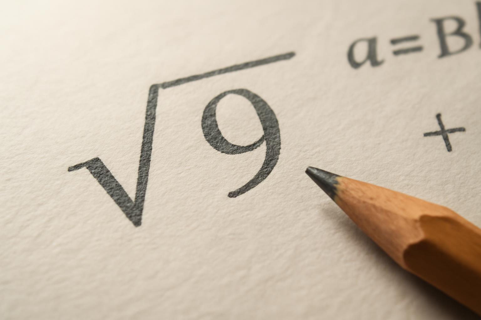 A négyzetgyök jelölése, a √9 kifejezés egy papírlapon, mellette egy ceruza.